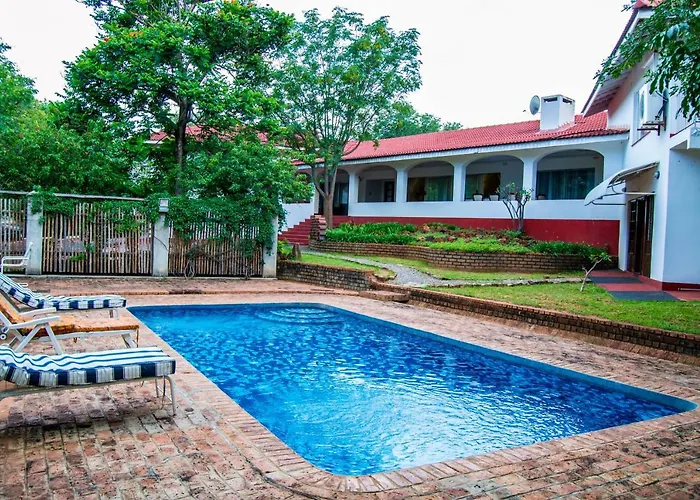 The White House Of Victoria Falls exterior with pool and red-tiled roof